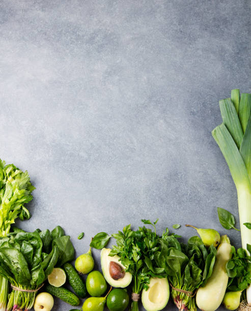 istock Green vegetables and herbs assortment on a grey stone background. Top view. Copy space 689531730