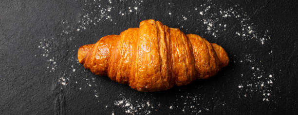 istock Fresh croissant on a black slate background. Top view. Copy space 689534090