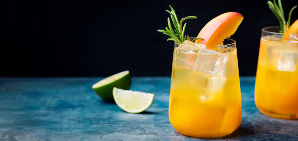 istock Peach cocktail, fizz with rosemary on blue stone background. Copy space 689534166