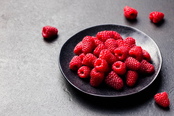 istock Fresh raspberries on a black bowl Slate background 689534454
