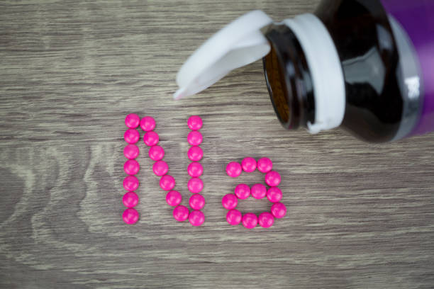 istock Pink pills forming shape to Na alphabet on wood background 689536986