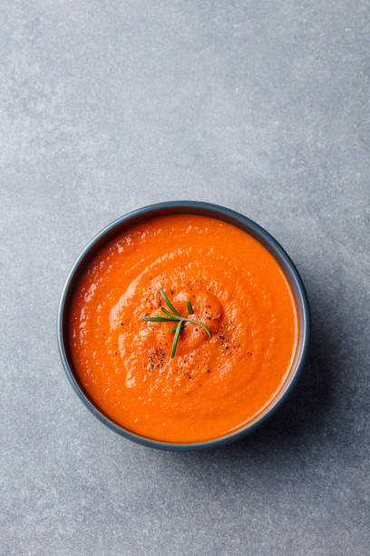 istock Tomato soup in a black bowl on grey stone background. Top view. Copy space 689537362