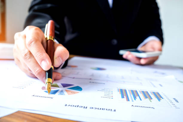 istock hand with a pen writing on the business paper. Report chart 689555328
