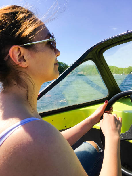 istock young woman drives old motorboat and have fun 689560498