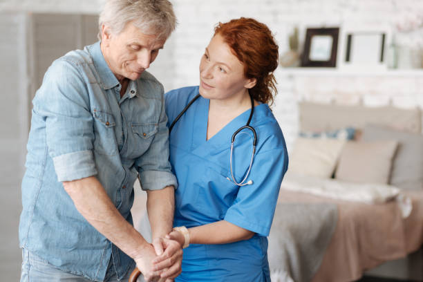 istock Friendly focused nurse encouraging her elderly patient 689561018