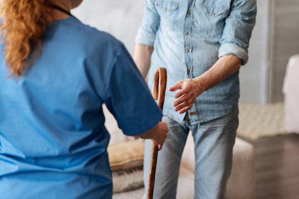 istock Committed kind medical worker giving her patient a cane 689561054