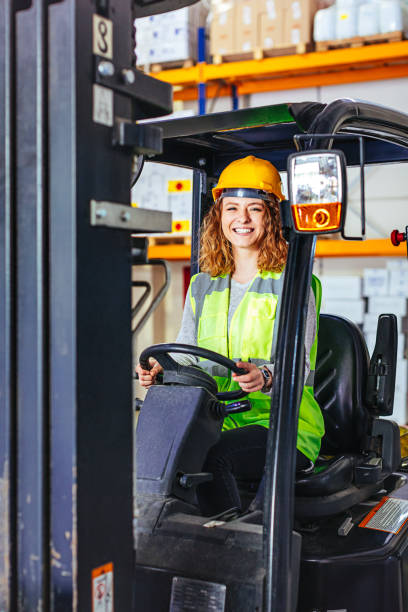 istock Young woman driving a forklift at warehouse 689561158