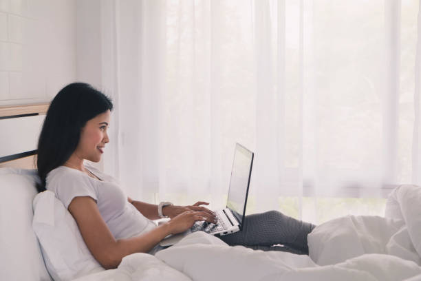 istock Young asian woman using laptop to working in bedroom. 689568344