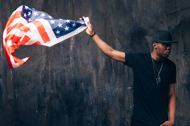 istock Afro american man hold in hand flying US flag 689572582