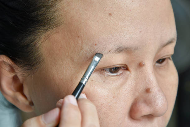 istock asian woman applying makeup with eyebrow brush 689579782