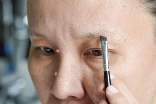 istock asian woman applying makeup with eyebrow brush 689579830