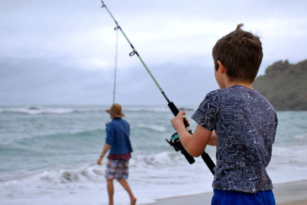 istock Boy and Man Surf Fishing in Summer 689582236