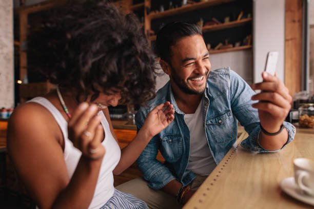 Couple at cafe taking selfie and laughing