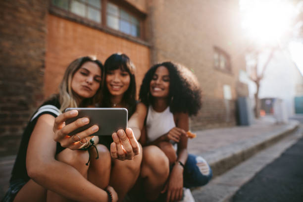 istock Three smiling female friends making selfie 689583148
