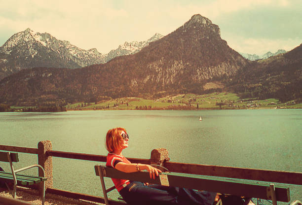 Taking a break at the Alps Vintage imageof a woman taking a break on a banch at the Alps european alps photos stock pictures, royalty-free photos & images
