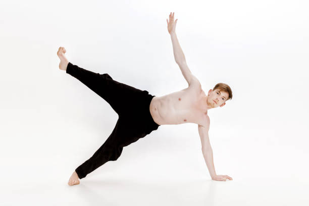 istock Young man doing yoga exercises. Studio shot on white background 689589936