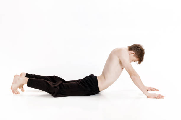 istock Young man doing yoga exercises. Studio shot on white background 689590164
