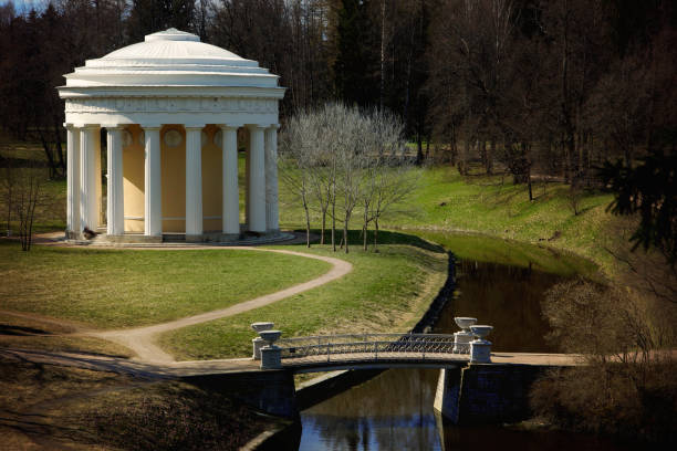 istock White classic arbor with columns in a beautiful park with paths and a bridge across a stream, horizontal 689598722