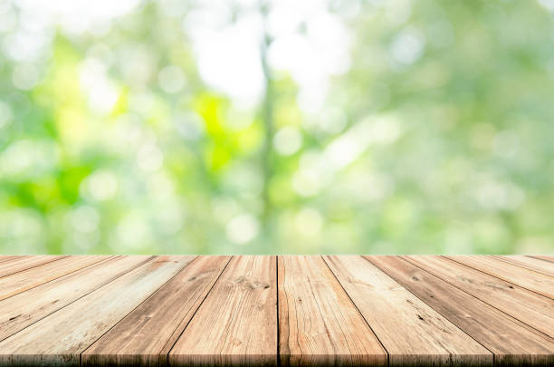 istock Empty wooden table top with blurred green natural abstract background. 689602676