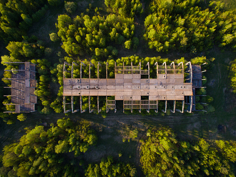 an unfinished, abandoned building overgrown with trees. conceptual background