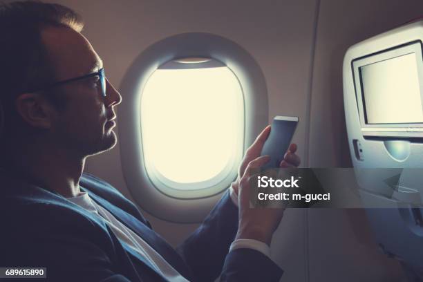 Man Using Smartphone In The Airplane Stock Photo - Download Image Now - Airplane, Mobile Phone, Portable Information Device
