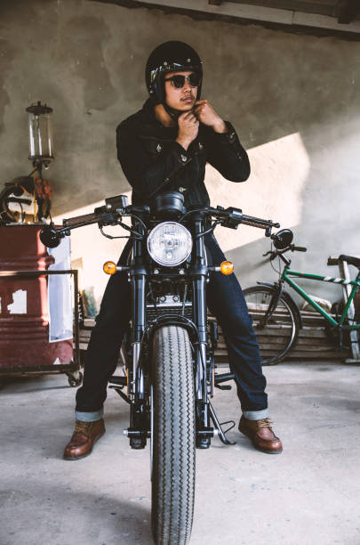 young man is wearing helmet on cafe racer motocycle young man is wearing helmet on cafe racer motocycle cafe racer stock pictures, royalty-free photos & images