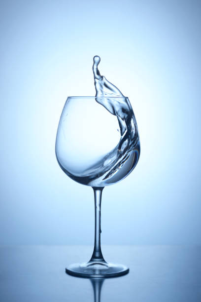istock Splash of blue water in a glass on a dark blue background with reflection 689629540