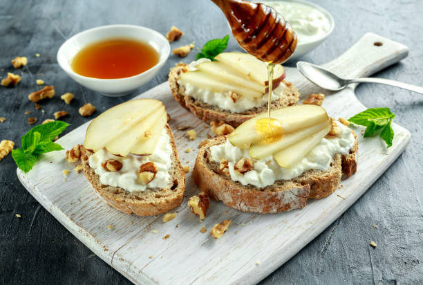 istock Appetizer bruschetta with pear, honey, walnut and cottage cheese on white board. 689633166