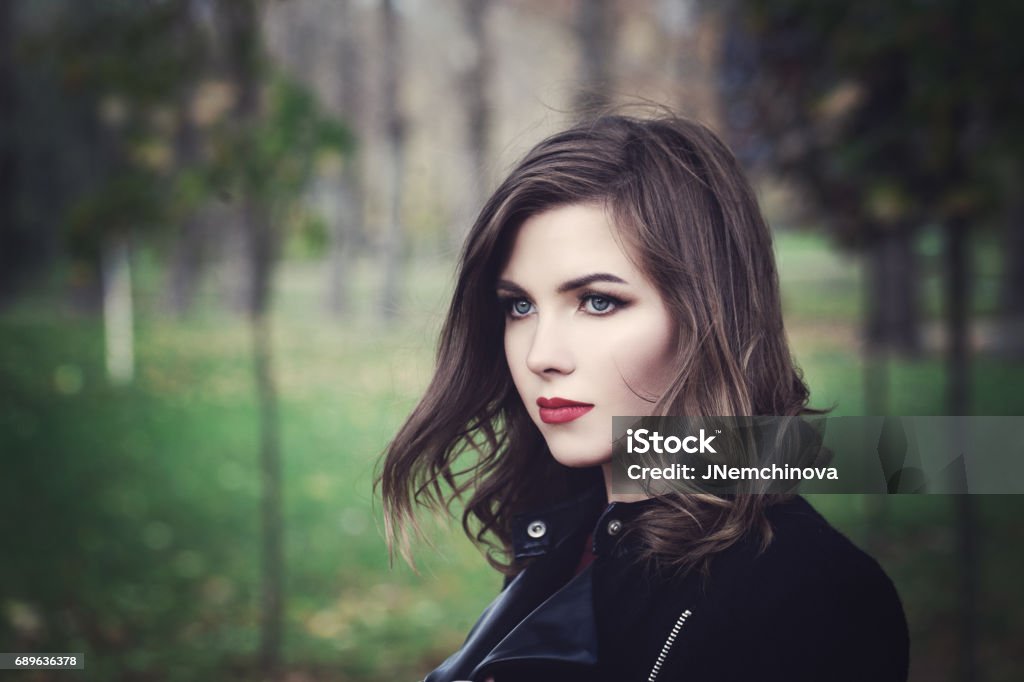 Beautiful Young Woman Fashion Model Walking in the Park. Outdoors Portrait Serious Stock Photo
