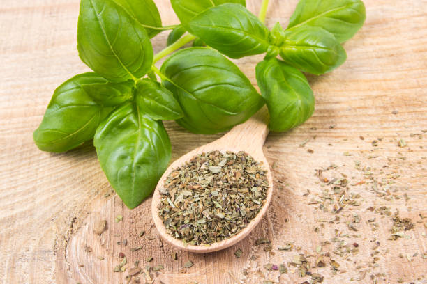 istock Raw green basil and dried, on the wooden table. 689641036