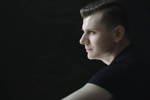 istock Side view head and shoulders young man portrait in low-key lighting 689643486