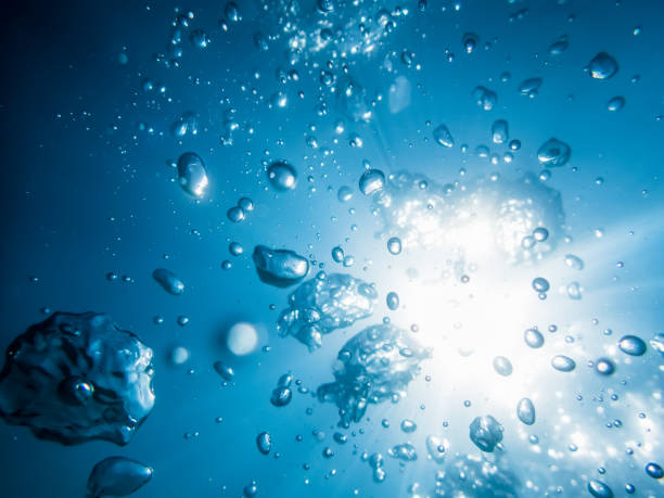 istock Bubbles and sun in underwater, in blue ocean. Water texture. 689651624