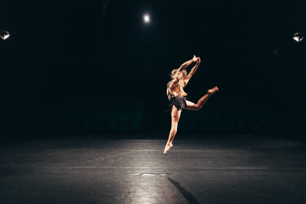 mujer sola en el escenario haciendo danza moderna performance - contemporary ballet fotografías e imágenes de stock