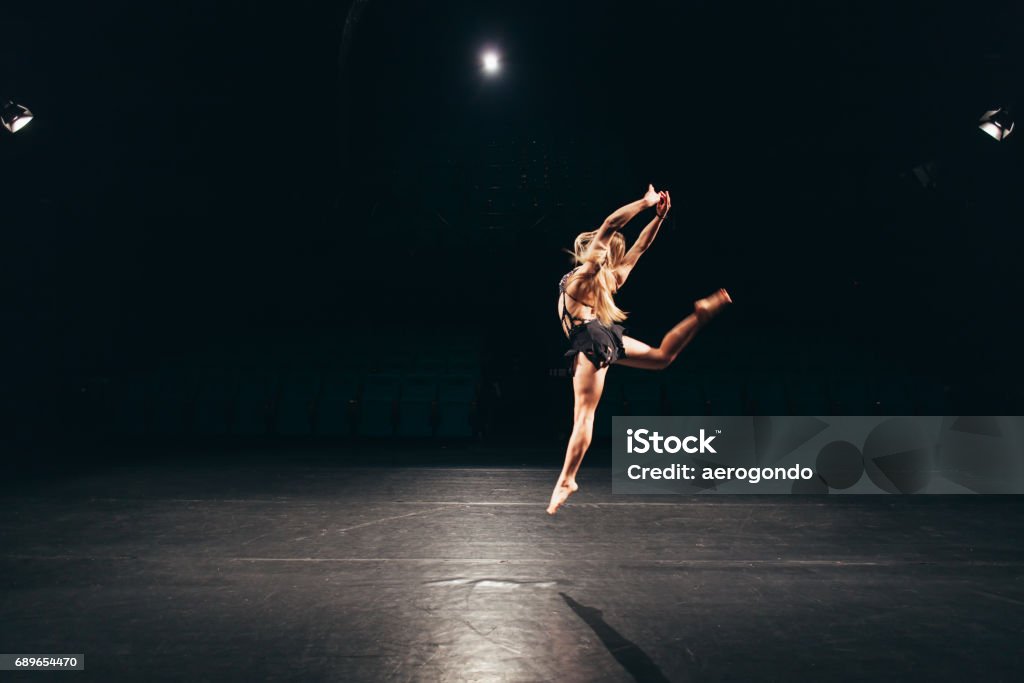 woman alone on stage doing modern dance performance young woman in dance costume alone on stage doing modern performance Dancing Stock Photo