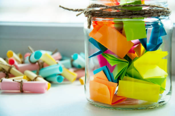 Glass jar with colored notes with blur and toning