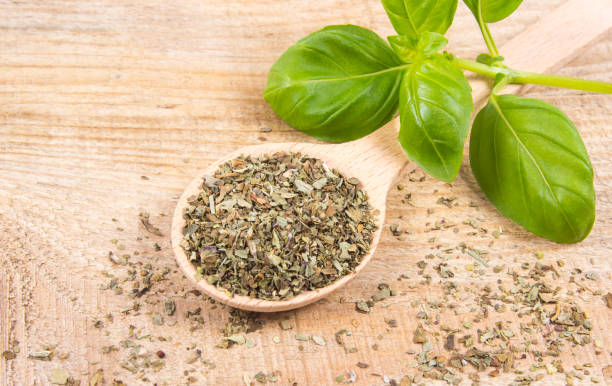 istock Raw green basil and dried, on the wooden table. 689670504
