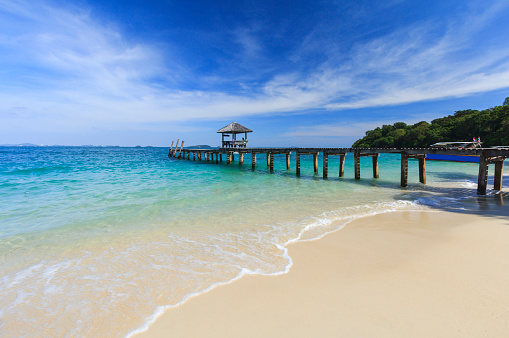 Wooden bridge pier leading to summer tropical sea with blue sky at Koh Samed Island, famous tourist attraction in Rayong province, Thailand.