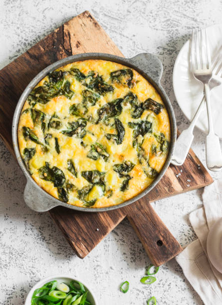 istock Potato and spinach tortilla in a pan on a light background. Delicious appetizer or snack, top view 689709362