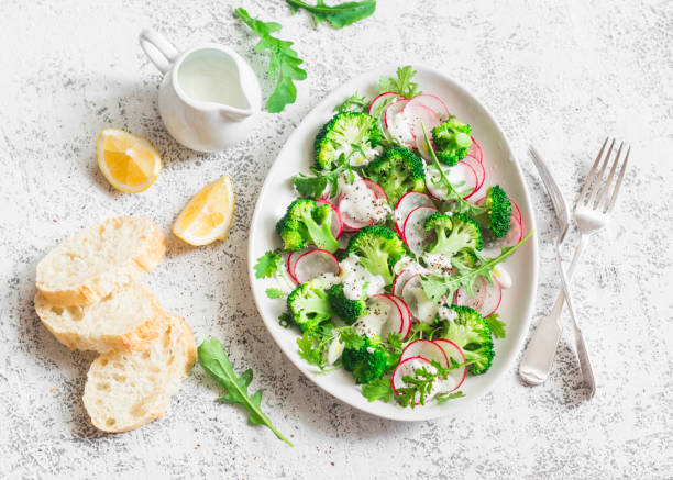 istock Spring broccoli and radish salad with yogurt sauce on a light background, top view. Delicious healthy vegetarian food concept 689709636