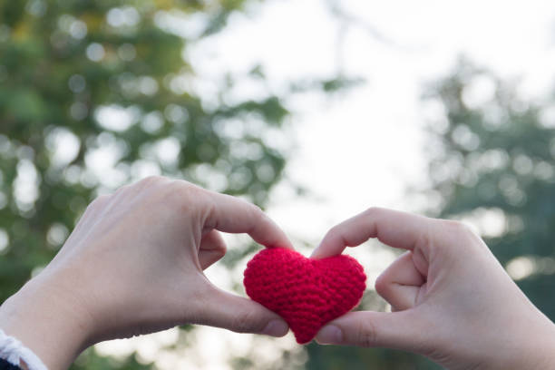 istock Woman finger made heart on white bokeh background 689734530