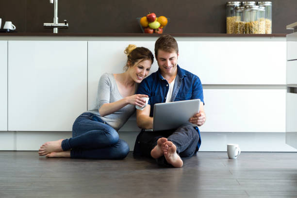 istock Beautiful young couple using they digital tablet in the kitchen at home. 689737782