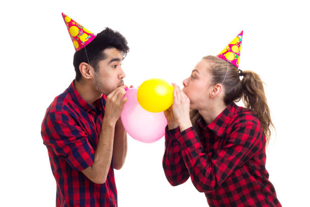istock Young couple blowing balloons 689746080