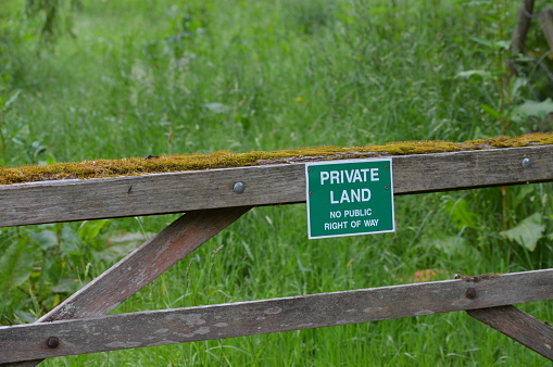 Private land sign attached to a wood gate.