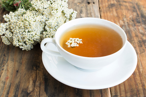 Yarrow Tea, Achillea Millefolium , on a Rustic Wooden Background.