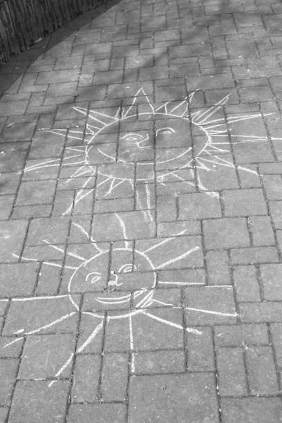 istock Chalk drawing of smiling sun on the road. 689756380