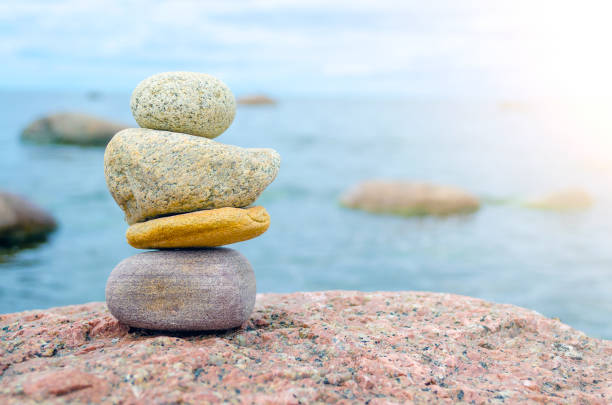 istock Pyramid of stones on a large stone beach and water. 689758660