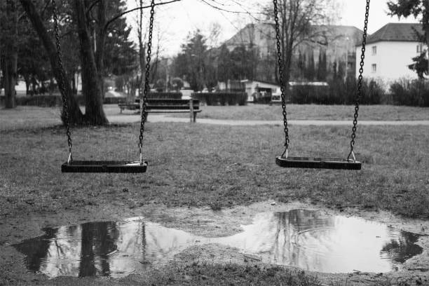 istock Swing on playground covered by rain during rainy day. 689759334