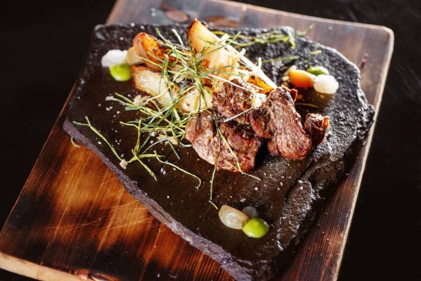 istock Grilled meat with vegetables, spices on a stone plate and wood background. selective focus 689759402