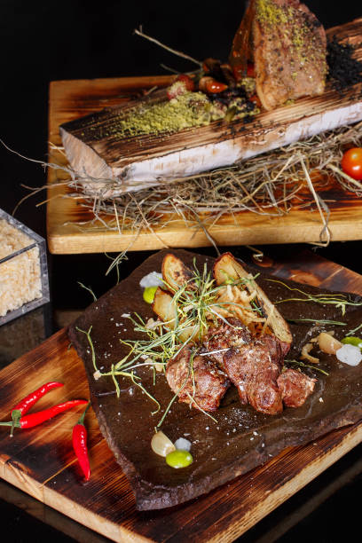 istock Grilled meat with vegetables, spices on a stone plate and wood background. selective focus 689759452