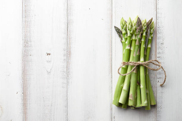 istock Bunch of fresh asparagus on wooden table 689766384